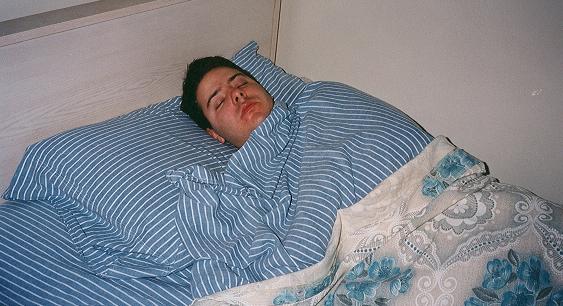 File:Man sleeping striped-sheets.JPG