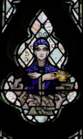 St. Brigid holds a golden lamp and an oak leaf.