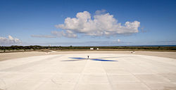 A person standing in the middle of the main landing pad demonstrates its size.