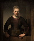 A young woman leaning over an open half-door.