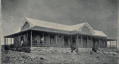 Workers standing on the veranda of a Dutch-style building