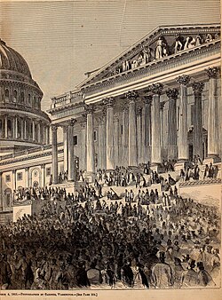 A large crowd in front of a large building with many pillars