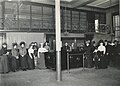 Female staff of the Old Main posing in front of the charging booth, black-and-white