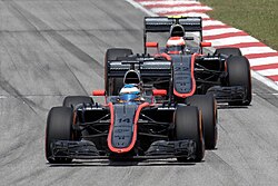 Two black-and-orange McLaren cars on track