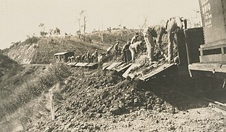 Workers emptying excavated soil from carriages next to the railway line, Kokotungo, 1928
