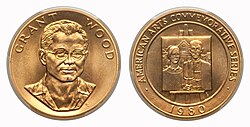 A gold medallion depicting a man and a painting