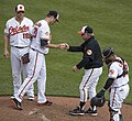 Image 9A pitcher handing off the ball after being taken out of the game during a mound meeting. (from Baseball)