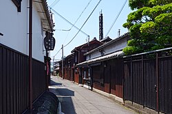 A small street lined by wooden two-storied houses.