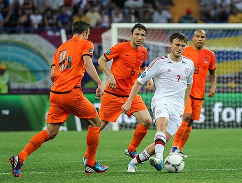 Players from the Netherlands national football team (wearing orange) vs. Denmark, Euro 2012. The team's nickname translates to "The Orange."