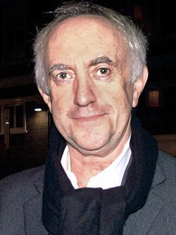 Jonathan Pryce looking towards the camera.