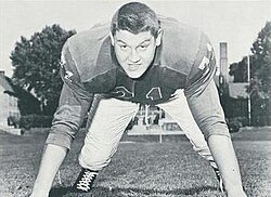 Alex Karras in a jersey and on his hands and toes, as if about to rush a passer.