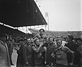 A man being carried by several other men on a racetrack