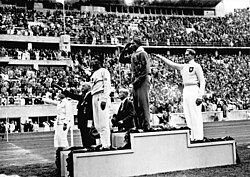 Three athletes standing on a tiered medal podium