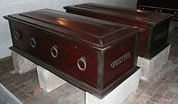 Two dark wooden coffins with metal ring handles, belonging to Johann Wolfgang von Goethe and Friedrich Schiller, displayed on stone supports in the Ducal Vault, Weimar.
