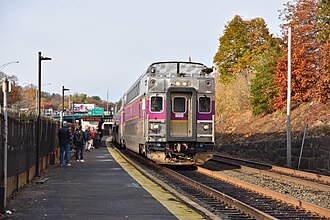 A passenger train arriving at a station with a low-level side platform and two tracks