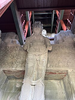 Statue of Shiyimian Guanyin, flanked by the Bodhisattvas Wenshu and Puxian at Tianlongshan Grottoes in Shanxi, China.