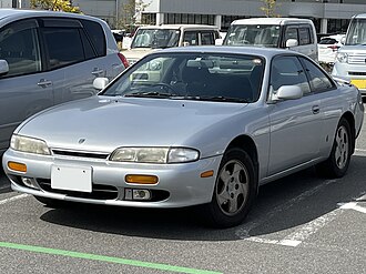 Front-three-quarter view of a two-door car with door mirrors, a sunroof, and a rear spoiler