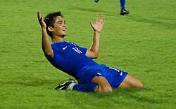 Chhetri on his knees in a blue football shirt and blue football shorts.