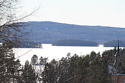 Åmänningen is covered in snow and ice. Villa Ulvaklev is in the foreground in the lower right corner. Landsberget is visible in the background. The picture is taken from Ängelsberg.
