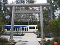 Timber gateway and a waiting train.  Facsimiles of historical newspaper headlines are at the base of the wooden poles.