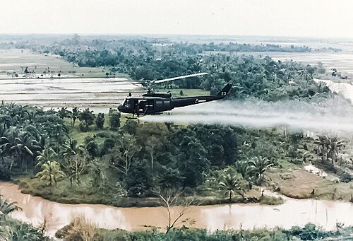 A US helicopter spraying Agent Orange on a jungle during the Vietnam War