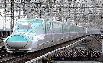 Teal and white bullet train with purple stripe