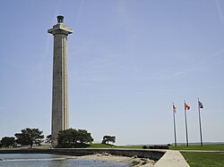 Doric column-shaped tower with trees at its base