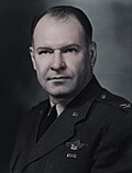 Man in uniform looking to the camera with hair slicked back.