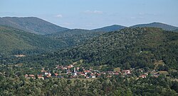 An overhead view of the village Spahići, which is surrounded by green hills.