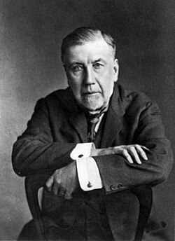 Black and white photo of Robertson sitting with arms folded
