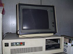 A 1980s white box IBM PC compatible with one full-height 5.25-inch drive bay containing a half-height 5.25-inch floppy drive