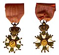 Late Empire Légionnaire insignia: the front features Napoleon's profile and the rear, the imperial Eagle. An imperial crown joins the cross and the ribbon.