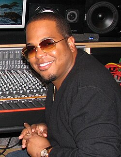 A picture of a man looking offset to the camera wearing sunglasses