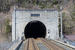 Train tracks entering mountain tunnel