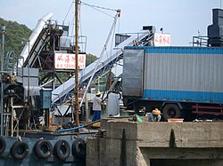 Loading blocks of factory-made ice from a truck to an ice depot boat