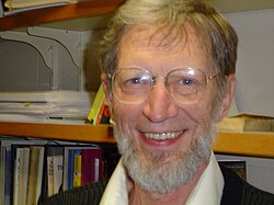 Head shot of a smiling, bespectacled, and bearded Plantinga in his seventies.