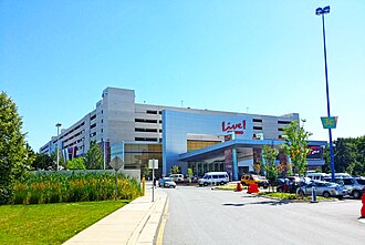 A sky blue building with red Live! wording with the text "CASINO" underneath it. A parking garage is behind the structure.