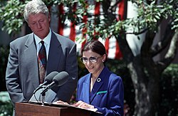 Ginsburg speaking at a lectern