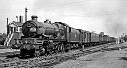 A long down parcels train approaches Tilehurst with No. 5002 'Ludlow Castle' on the point in June 1962