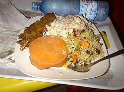 Nigerian fried rice with fish, salad and steamed bean pudding