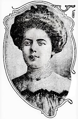 Mallon, looking just left of camera. Her hair is made up on top of her head and she wears a high-necked blouse
