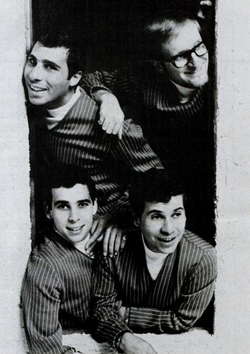 A promotional photo of the Tokens taken in 1967, showing them by what appears to be a large opening in a wall; they are grinning and sporting matching striped outfits
