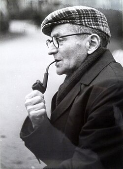 An old man smoking a pipe, looking to the left