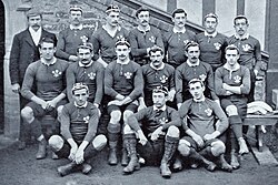 Three rows of rugby players wearing their playing uniforms and caps