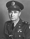Man with army uniform looking at camera with serious face.