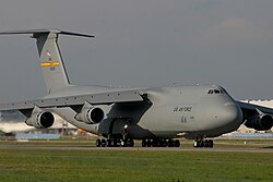 C-5B Galaxy strategic airlifter parked on an airfield ramp showing its distinctive high-wing and T-tail configuration