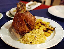 Schweinshaxe served with roasted potatoes (Bratkartoffeln) and Sauerkraut at a Bavarian restaurant in Chiang Mai, Thailand