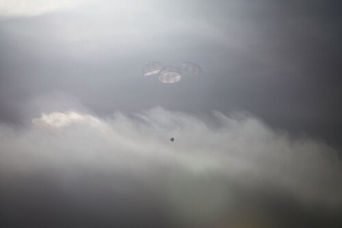 Dragon descending under parachute