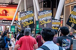 A crowd of people holding signs readings "Long Island Rail Road Brotherhood of Locomotive Engineers and Trainmen Teamsters on Strike"