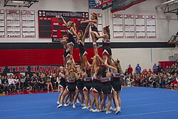 Gymnastics performed as part of cheerleading at high school in United States.